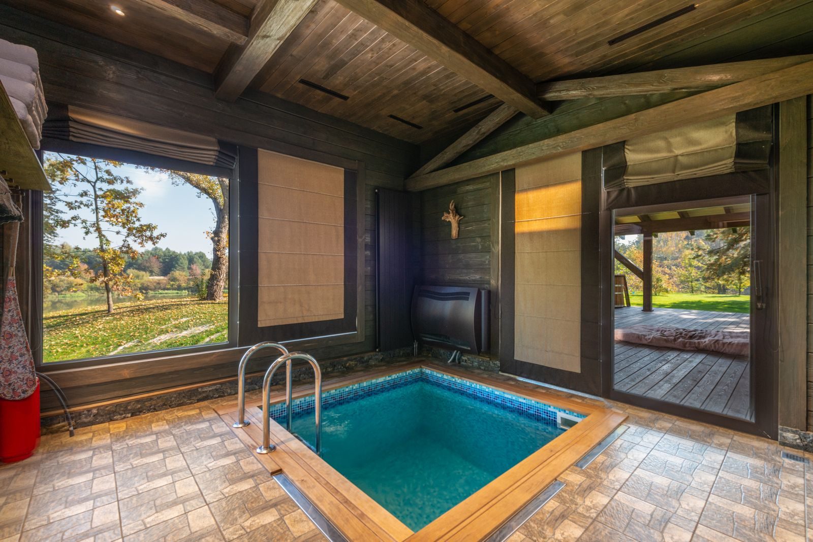 Innenliegendes Schwimmbad in einem Wohnhaus mit Holzdecke und großen Fenstern